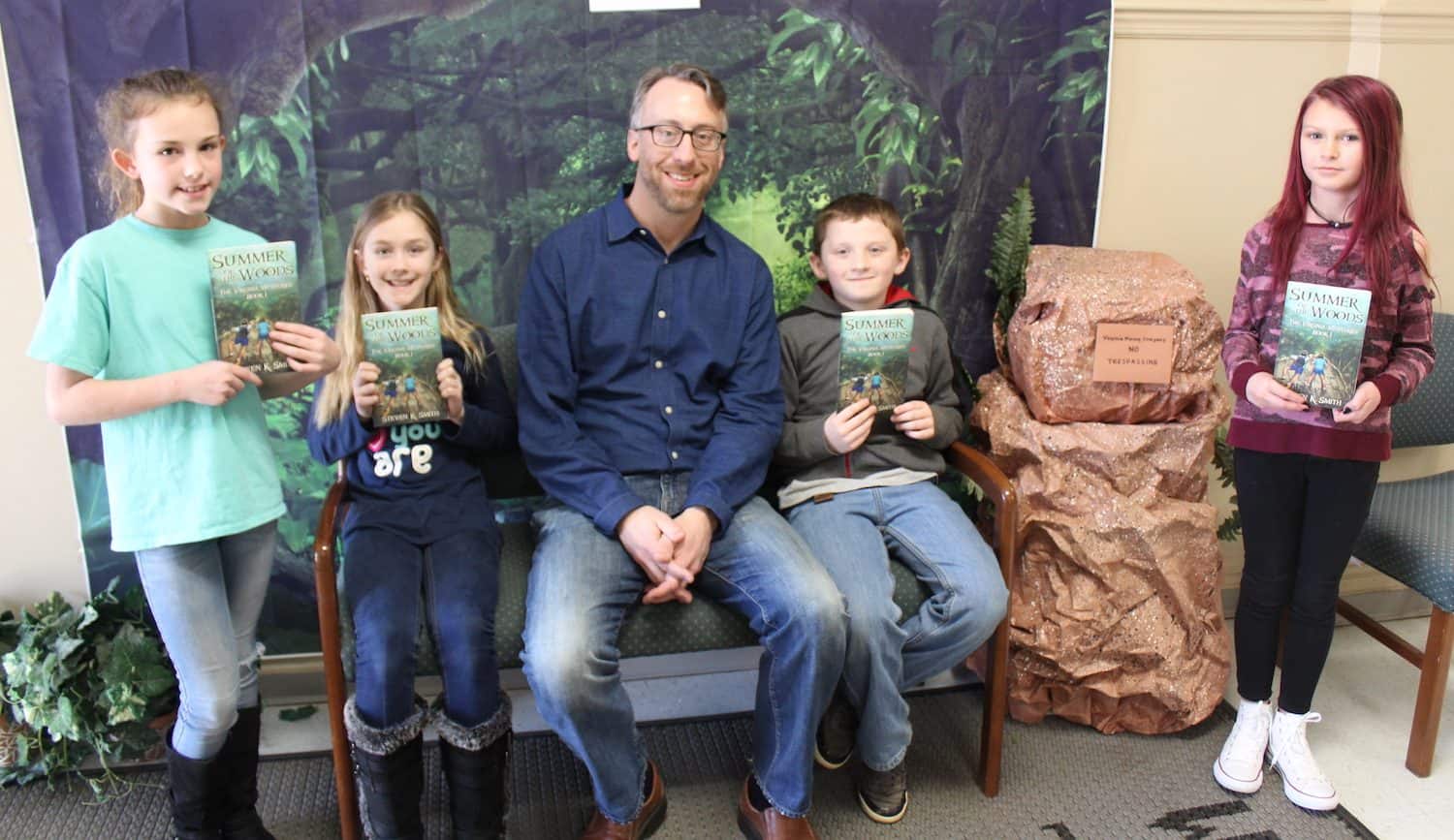 Students holding their signed Virginia Mysteries books with Steven
